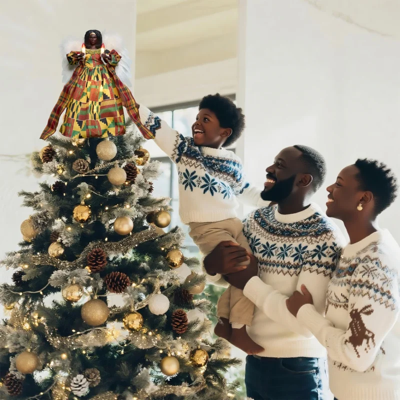 Heartwarming Christmas moment: father helps boy put a kente black angel tree topper while mother looks on smiling