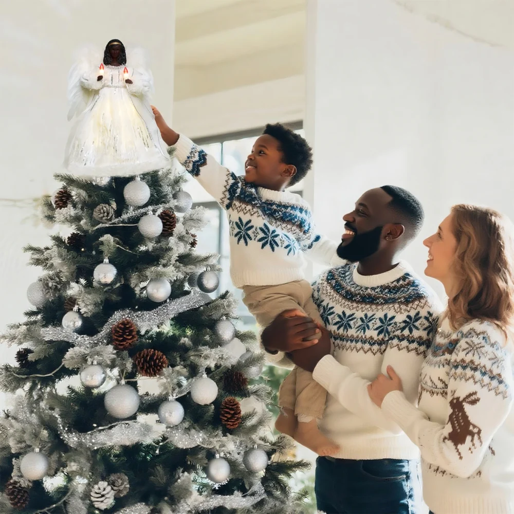 Heartwarming Christmas moment: father helps boy put a gold black angel tree topper while mother looks on smiling